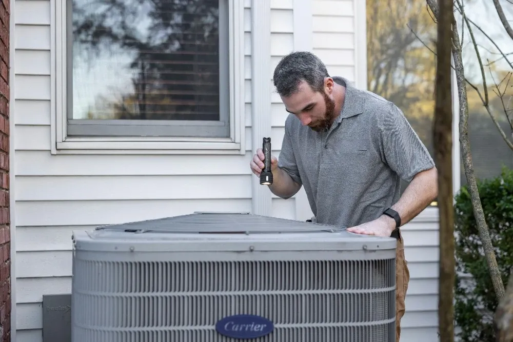 HVAC technician servicing an outdoor air conditioner unit